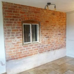 External brick wall recovered from underneath damp plaster.